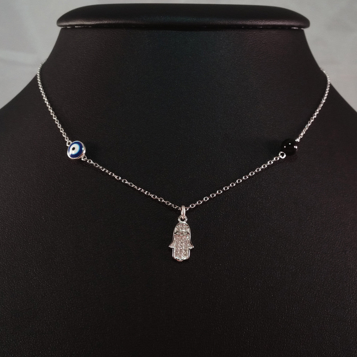 925 STERLING SILVER NECKLACE WITH TURKISH EVIL EYE CHARM AND HAMSA HAND PENDANT SET IN SPARKLING CRYSTALS.