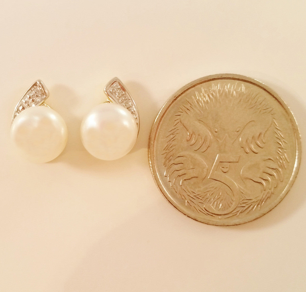 9K SOLID GOLD 7.00MM FRESHWATER PEARL AND DIAMOND EARRINGS.