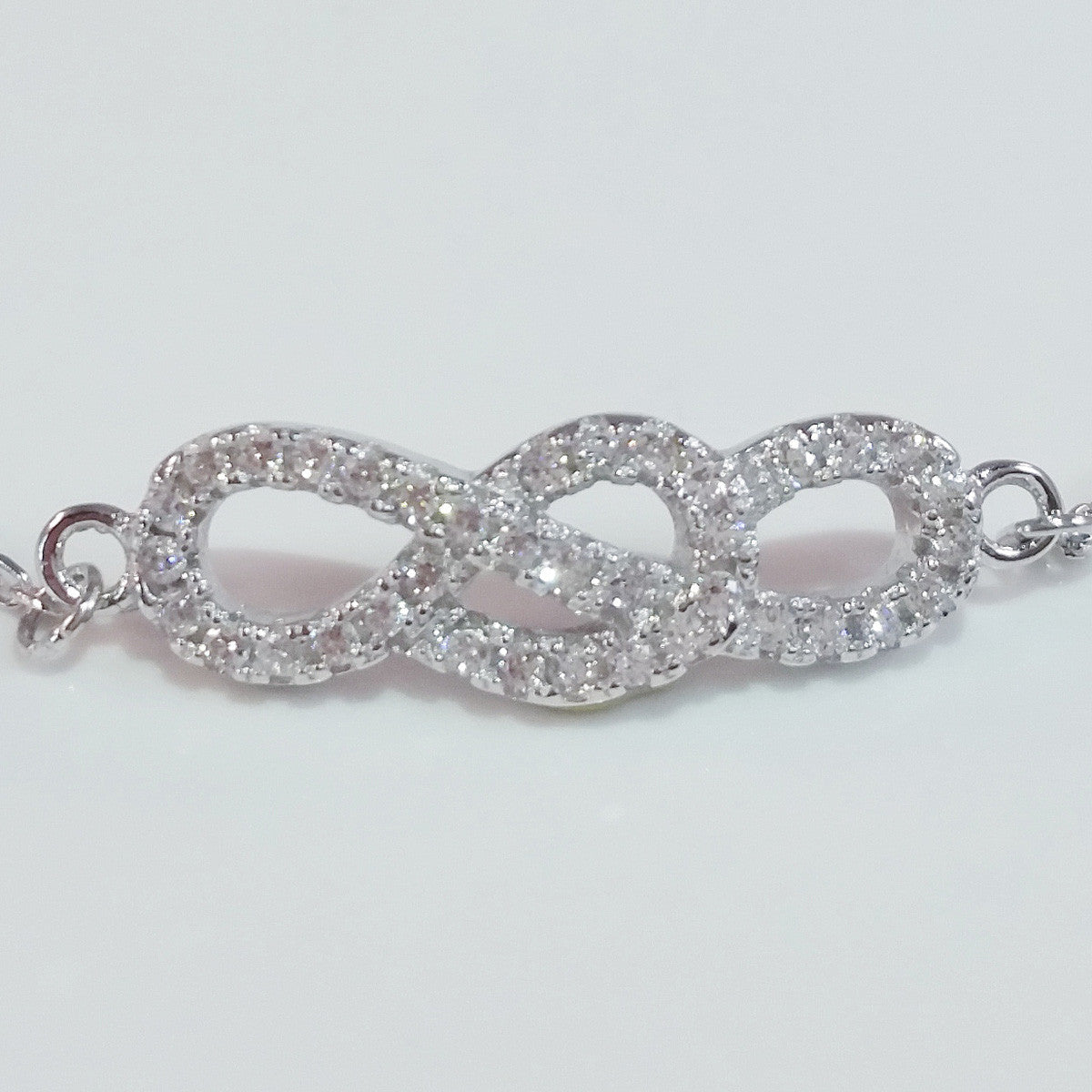 925 STERLING SILVER BRACELET WITH INFINITY CHARM PAVED WITH SPARKLING CZ CRYSTALS.