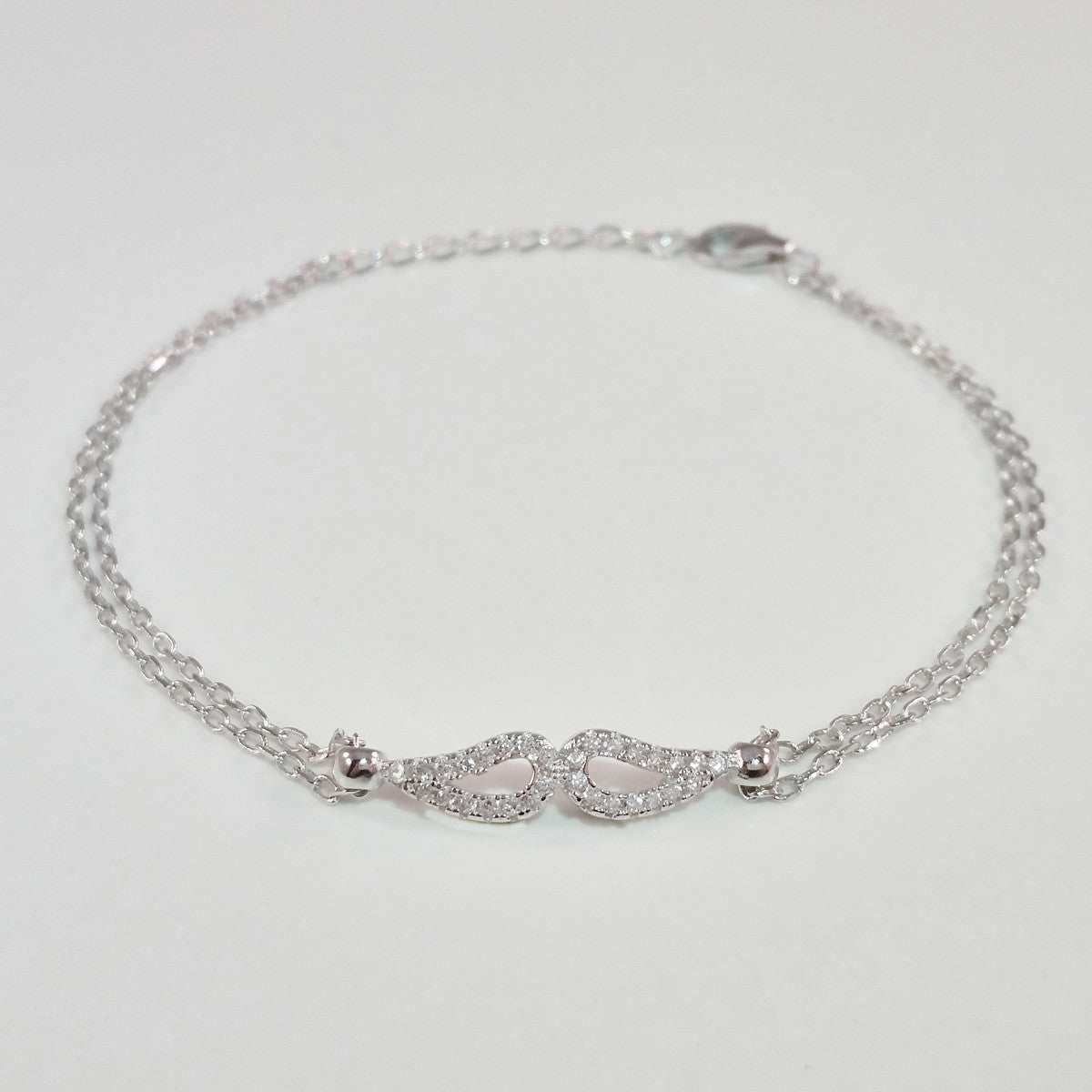 925 STERLING SILVER BRACELET WITH ANGEL WINGS CHARM PAVED WITH SPARKLING CZ CRYSTALS.