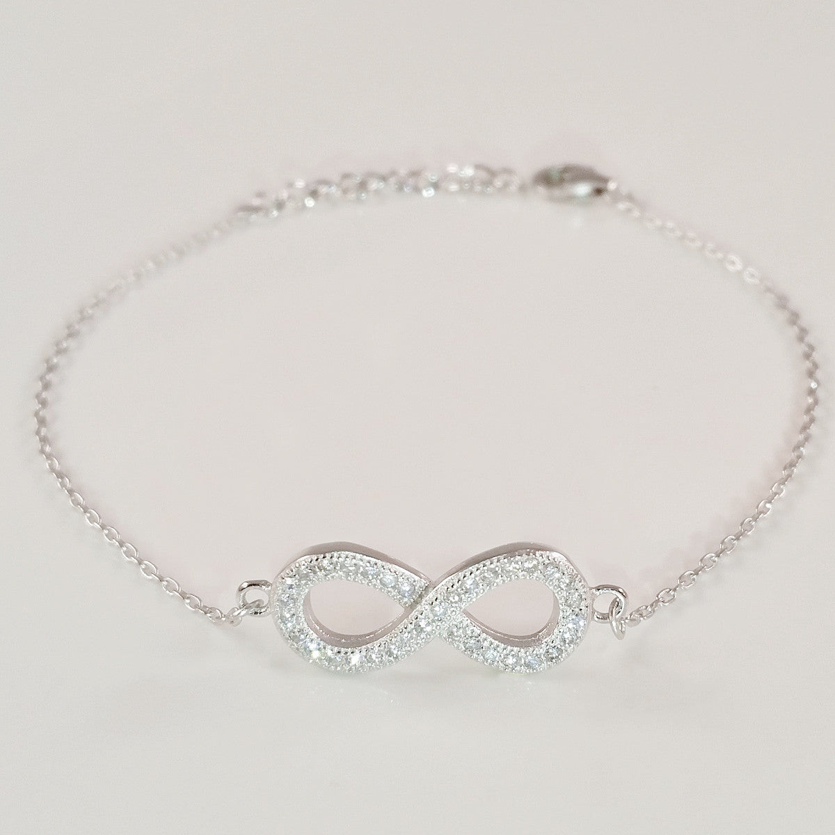 925 STERLING SILVER BRACELET WITH ETERNITY CHARM PAVED WITH SPARKLING CZ CRYSTALS.