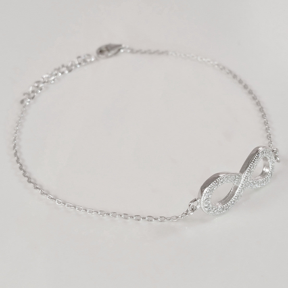 925 STERLING SILVER BRACELET WITH ETERNITY CHARM PAVED WITH SPARKLING CZ CRYSTALS.