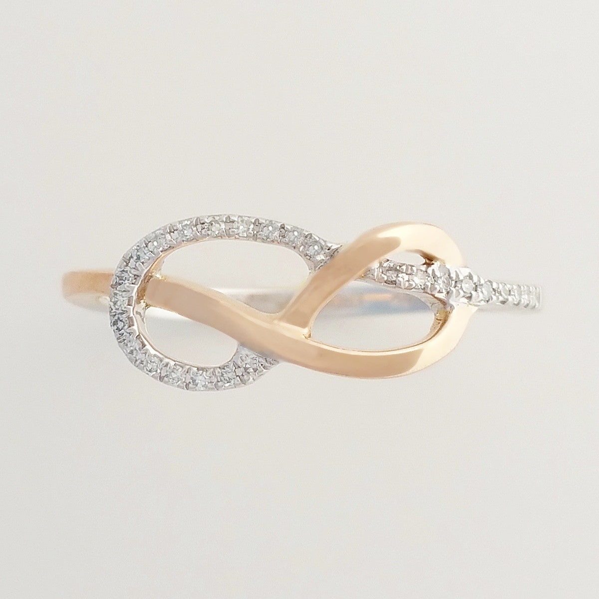 9K SOLID ROSE GOLD & WHITE GOLD INFINITY RING WITH 26 DIAMONDS.