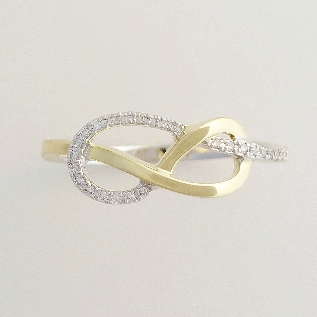 9K SOLID WHITE GOLD & YELLOW GOLD INFINITY RING WITH 26 DIAMONDS.