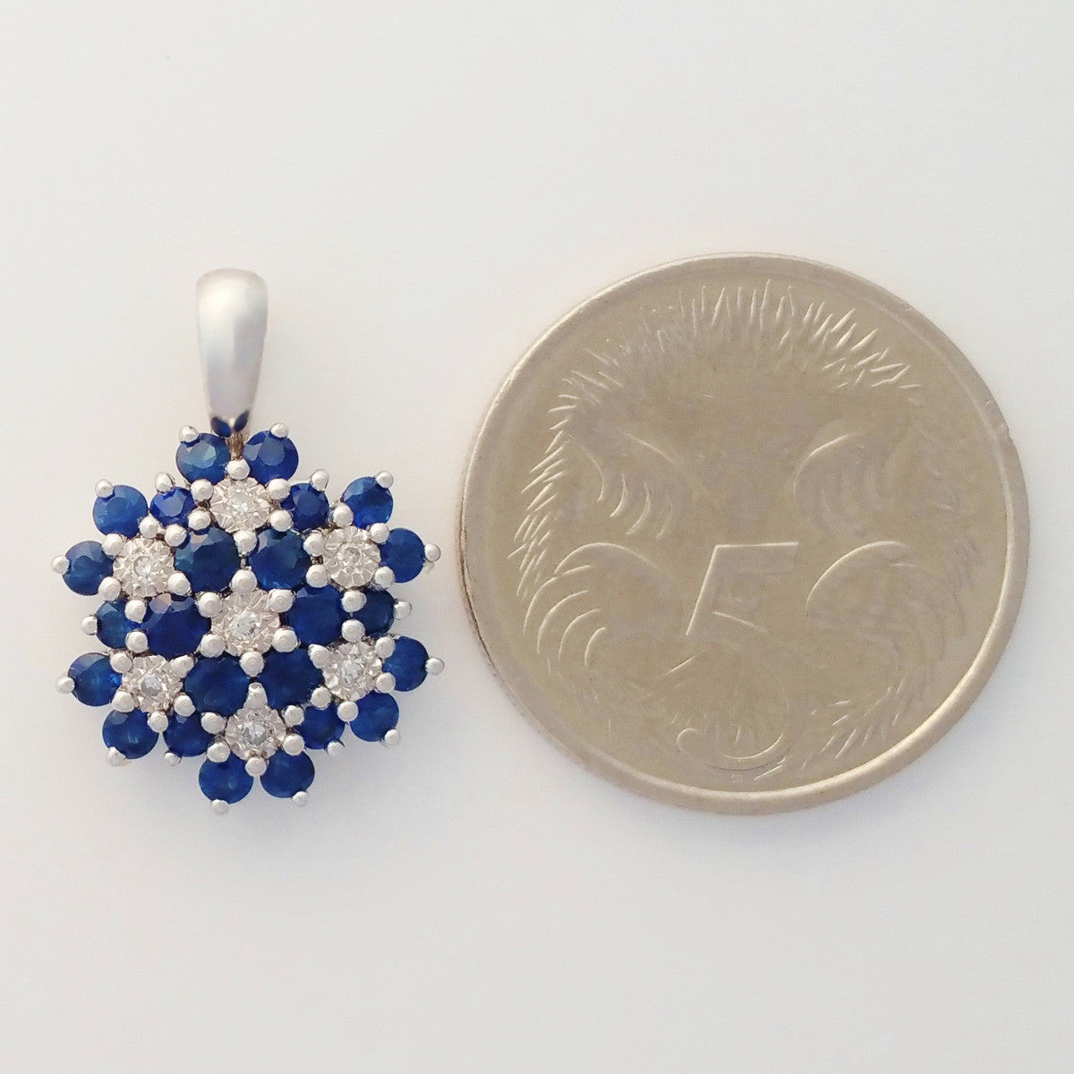 9K SOLID WHITE GOLD 0.85CT NATURAL SAPPHIRE CLUSTER PENDANT WITH SEVEN DIAMONDS.