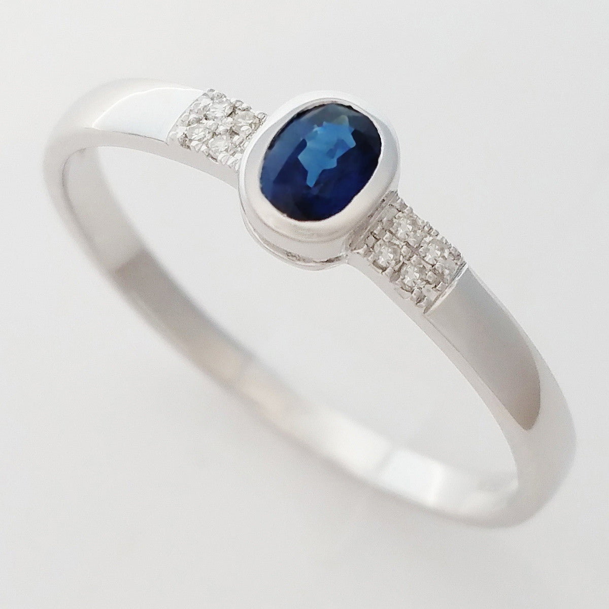 9K SOLID WHITE GOLD 0.25CT NATURAL OVAL BLUE SAPPHIRE RING WITH 8 DIAMONDS.