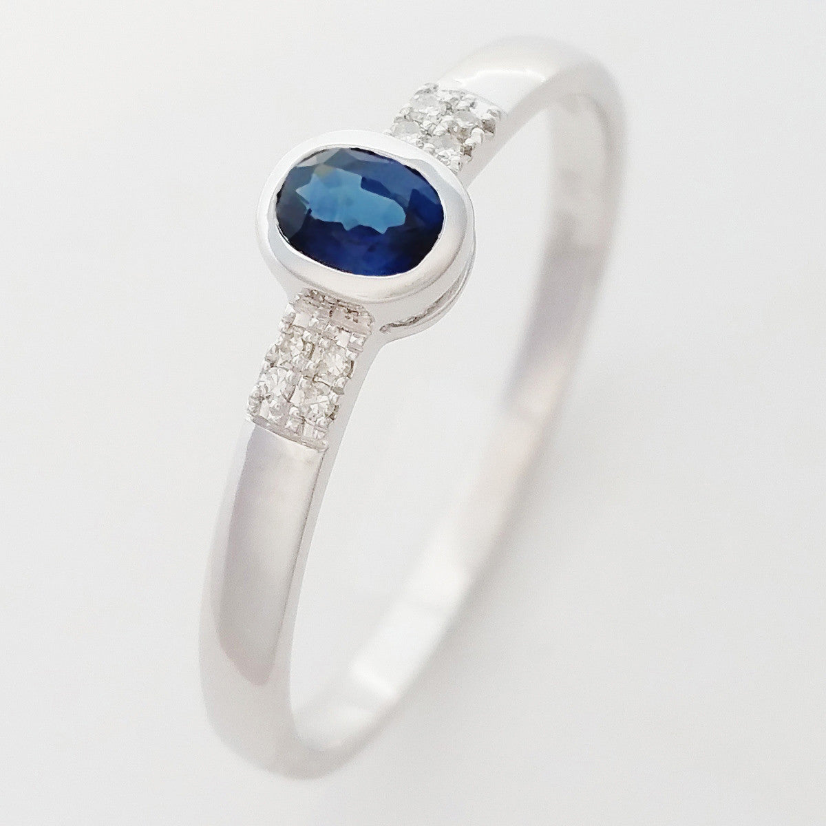 9K SOLID WHITE GOLD 0.25CT NATURAL OVAL BLUE SAPPHIRE RING WITH 8 DIAMONDS.