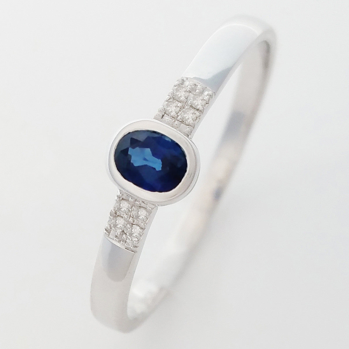 9K SOLID WHITE GOLD 0.25CT NATURAL OVAL BLUE SAPPHIRE RING WITH 8 DIAMONDS.