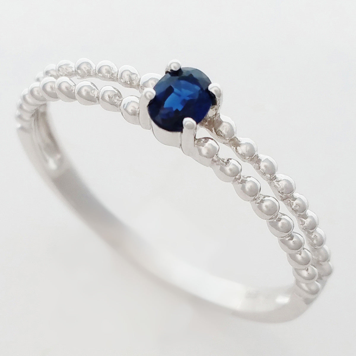 9K SOLID WHITE GOLD 0.25CT NATURAL SAPPHIRE RING WITH BEADED SHOULDERS.