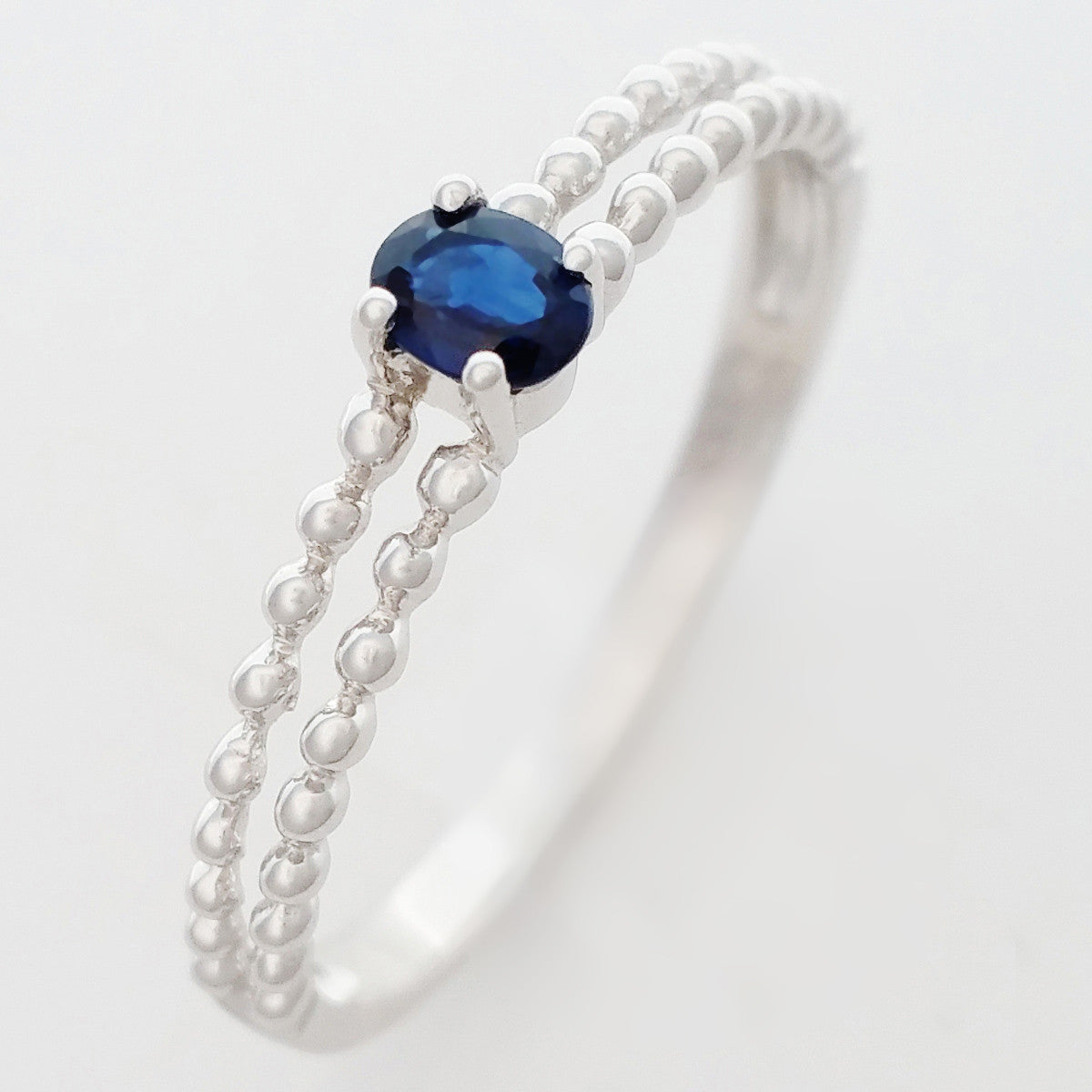 9K SOLID WHITE GOLD 0.25CT NATURAL SAPPHIRE RING WITH BEADED SHOULDERS.