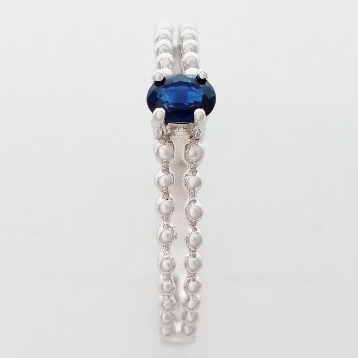 9K SOLID WHITE GOLD 0.25CT NATURAL SAPPHIRE RING WITH BEADED SHOULDERS.