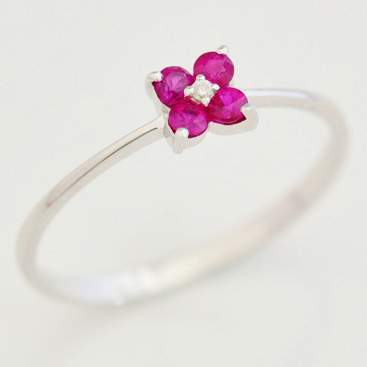 9K SOLID WHITE GOLD 0.20CT RUBY FLORAL CLUSTER RING WITH CENTRE DIAMOND.