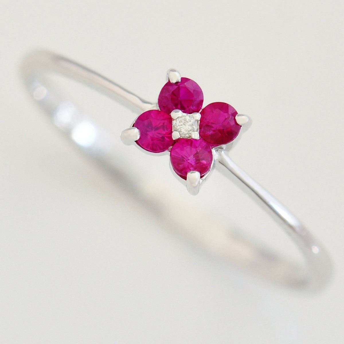 9K SOLID WHITE GOLD 0.20CT RUBY FLORAL CLUSTER RING WITH CENTRE DIAMOND.
