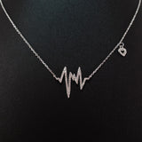 925 STERLING SILVER NECKLACE WITH EKG HEARTBEAT PENDANT SET IN SPARKLING CRYSTALS.