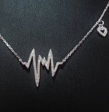 925 STERLING SILVER NECKLACE WITH EKG HEARTBEAT PENDANT SET IN SPARKLING CRYSTALS.