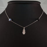 925 STERLING SILVER NECKLACE WITH TURKISH EVIL EYE CHARM AND HAMSA HAND PENDANT SET IN SPARKLING CRYSTALS.
