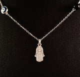 925 STERLING SILVER NECKLACE WITH TURKISH EVIL EYE CHARM AND HAMSA HAND PENDANT SET IN SPARKLING CRYSTALS.